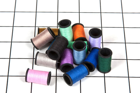 Colorful Spools Of Thread On A Sewing Mat