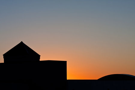 Sunrise behind silhouette building in the early morning.