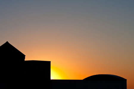 Sunrise behind silhouette building in the early morning.の写真素材