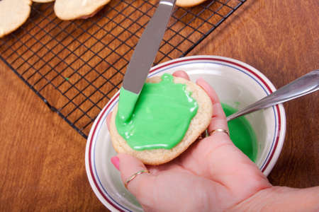 Frosting fresh baked cookies right out of the ovenの写真素材
