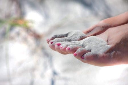 Sandy feet of a woman on the beach