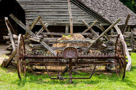 Old cultivator sitting on an old working farmの写真素材