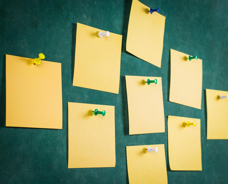 Empty paper,Note Paper,white paper Blank Yellow paper ,Blank Yellow, paper on green board with tack pin for text and backgroundの写真素材