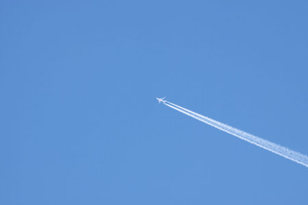 Jet airplane on almost clear blue sky witch some clouds
