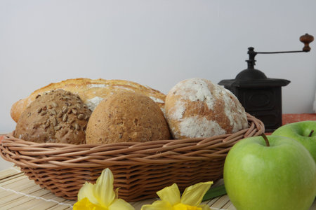 Variety of whole wheat bread in basket and greena applesの写真素材