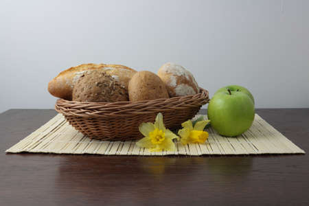 Variety of whole wheat bread in basket and greena applesの写真素材