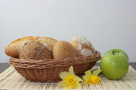 Variety of whole wheat bread in basket and greena applesの写真素材