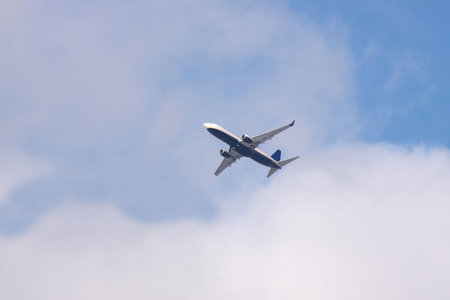 Jet airplane on almost clear blue sky witch some cloudsの写真素材
