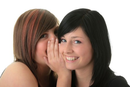 Two happy young girlfriends (sisters) talking over white
