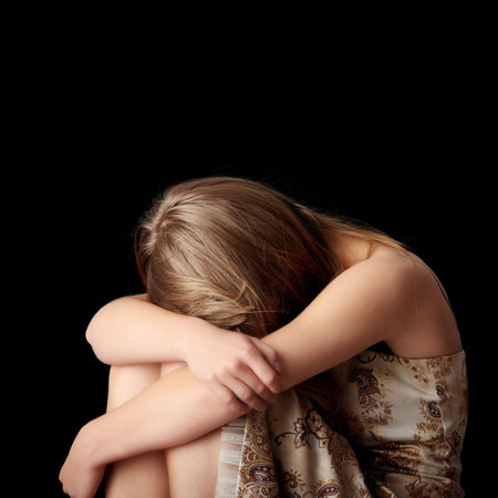 Young woman depression isolated on black backgroundの写真素材