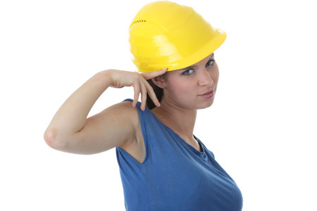Young female architect or builder wearing a yellow hart hat on a construction site