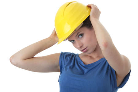 Young female architect or builder wearing a yellow hart hat on a construction siteの写真素材