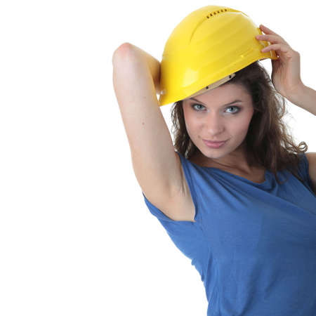 Young female architect or builder wearing a yellow hart hat on a construction siteの写真素材