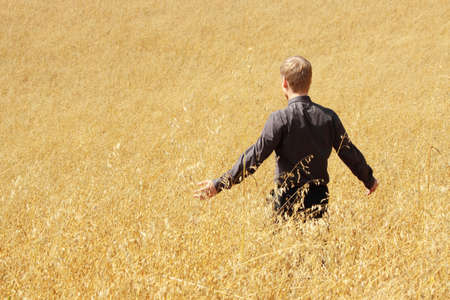 Young modern farmer in suit standing in field of oats

の写真素材