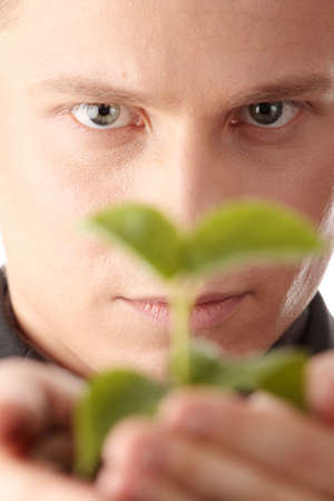 Businessman in dark suit holding smal plant in his hands - growth conceptの写真素材