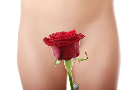 Beautiful red rose against young nude caucasian woman in backgroundの写真素材