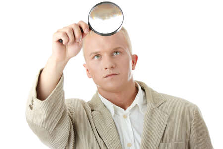 Young business man looking through loupe close upの写真素材