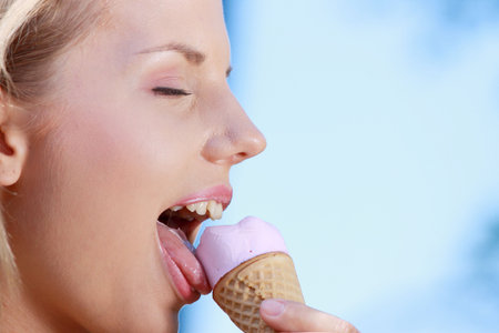 Portrait of young happy woman eating ice-cream, outdoor