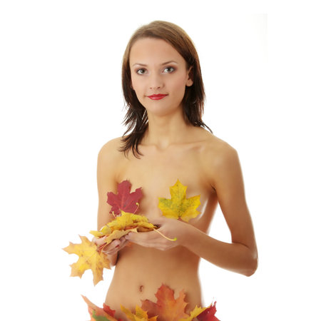 Young nude caucasian woman playing with autumn colorful leaves. Isolated on whiteの写真素材