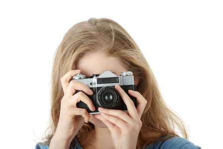 Pretty girl making photo using classic slr camera. Isolated on white
の写真素材
