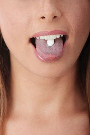 Extreme close-up image of a young woman taking a pill.
の写真素材