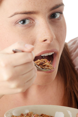 Young house wife eating muslin, isolated on white