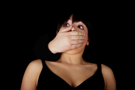 Young woman is being silenced by man, isolated on black
の写真素材