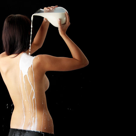 Young beautiful woman with milk, isolated on black. Skin care conceptの写真素材