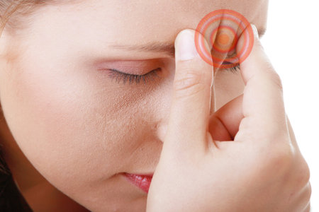Woman with severe Migraine Headache holding hands to head