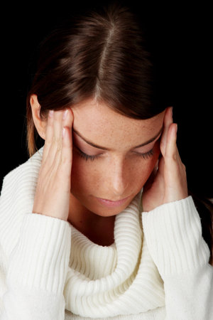 Woman with headache holding her hand to the head

