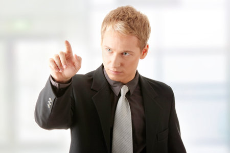 Business man pressing an abstract touchscreen button
の写真素材