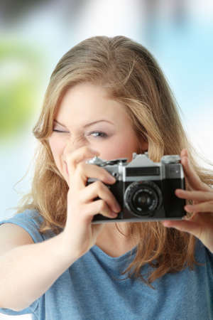 Pretty girl making photo using classic slr camera. の写真素材