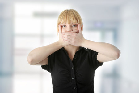 Young woman covering her mouth with hand, isolated on white background