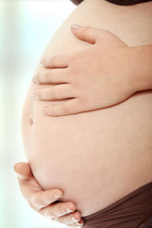 Belly of a pregnant woman with her hands on itの写真素材