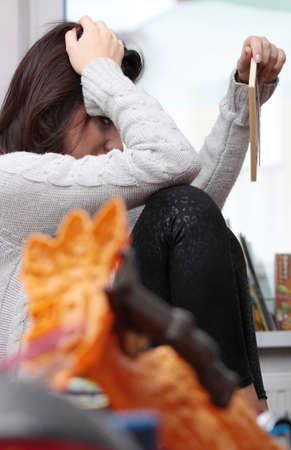 Young sad woman sitting in children room (lost of child concept)の写真素材