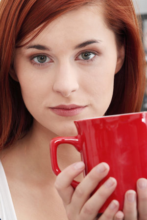 Beautiful lady is drinking coffee at homeの写真素材