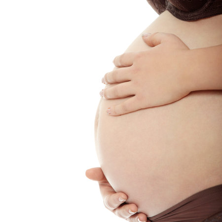 Belly of a pregnant woman with her hands on it, isolated on white 