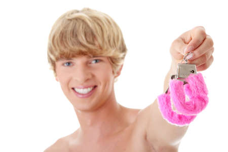 Young caucasian man with pink handcuff. Isolated on white の写真素材