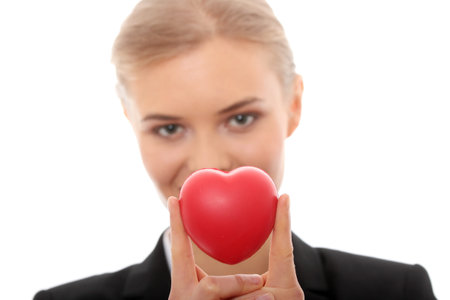 Young business woman holding heart shaped toy の写真素材
