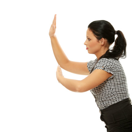 Businesswoman pushing something imaginary isolated on a white backgroundの写真素材