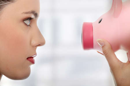 Businesswoman holding piggy bank. の写真素材