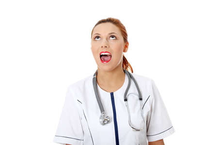 Shocked female doctor or nurse looking up , isolated on white の写真素材