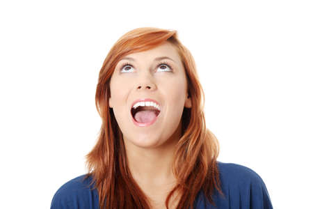 Surprised young woman looking up , isolated on whiteの写真素材