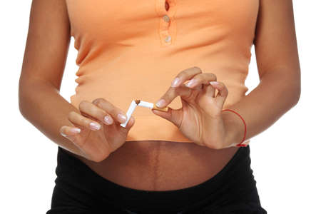 Pregnant woman breaking a cigarette - stop smoking concept の写真素材