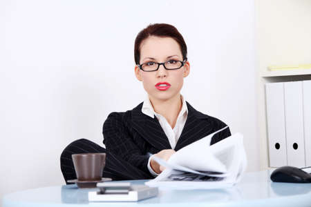 Pretty caucasian mad businesswoman sitting in the office showing files.の写真素材