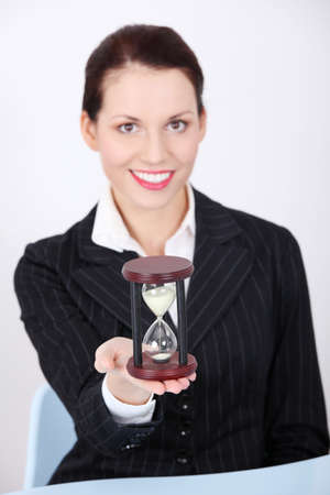 Pretty caucasian businesswoman holding hourglass.の写真素材