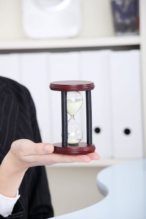 Closeup on hourglass in caucasian woman`s hand.