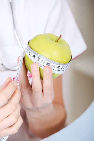Closeup on measuring apple in caucasian woman`s hands.の写真素材