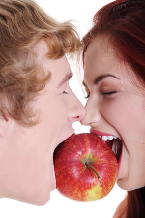 Closeup of young caucasian coupe biting apple over against white background.の写真素材