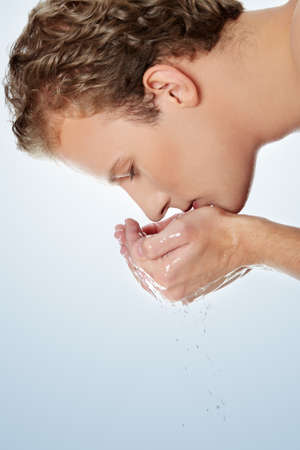 Young handsome man washing his faceの写真素材